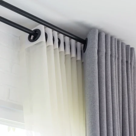 white sheer curtain with grey curtain on top with two black curtain poles