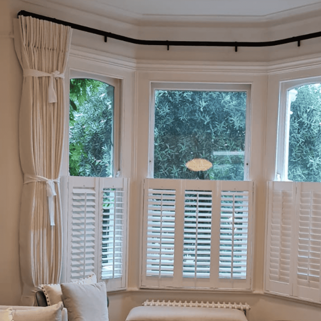White curtains with white venation blinds and black curtain pole