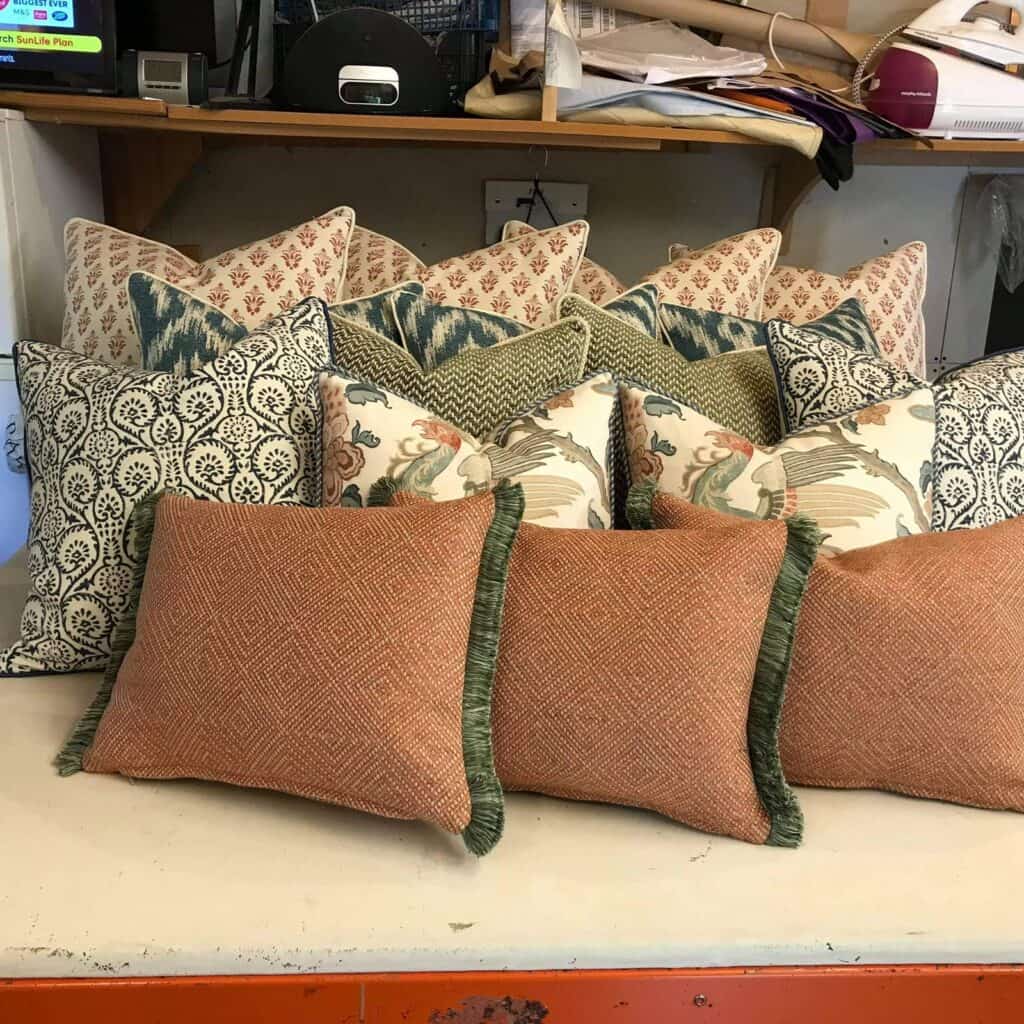 Four White cushions with red pattern, 3 green cushions with white pattern, 2 green and cream texture cushions, 2 white cushions with green pattern,2 cream 3 red cushions with green trim