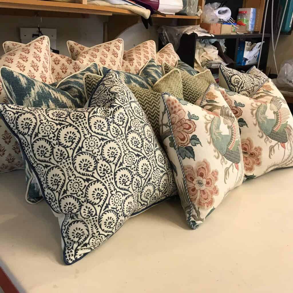 Four White cushions with red pattern, 3 green cushions with white pattern, 2 green and cream texture cushions, 2 white cushions with green pattern,2 cream cushions with pattern