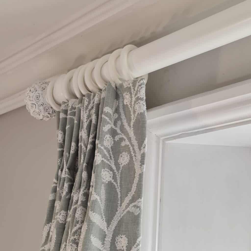 White curtain pole with grey and white curtains